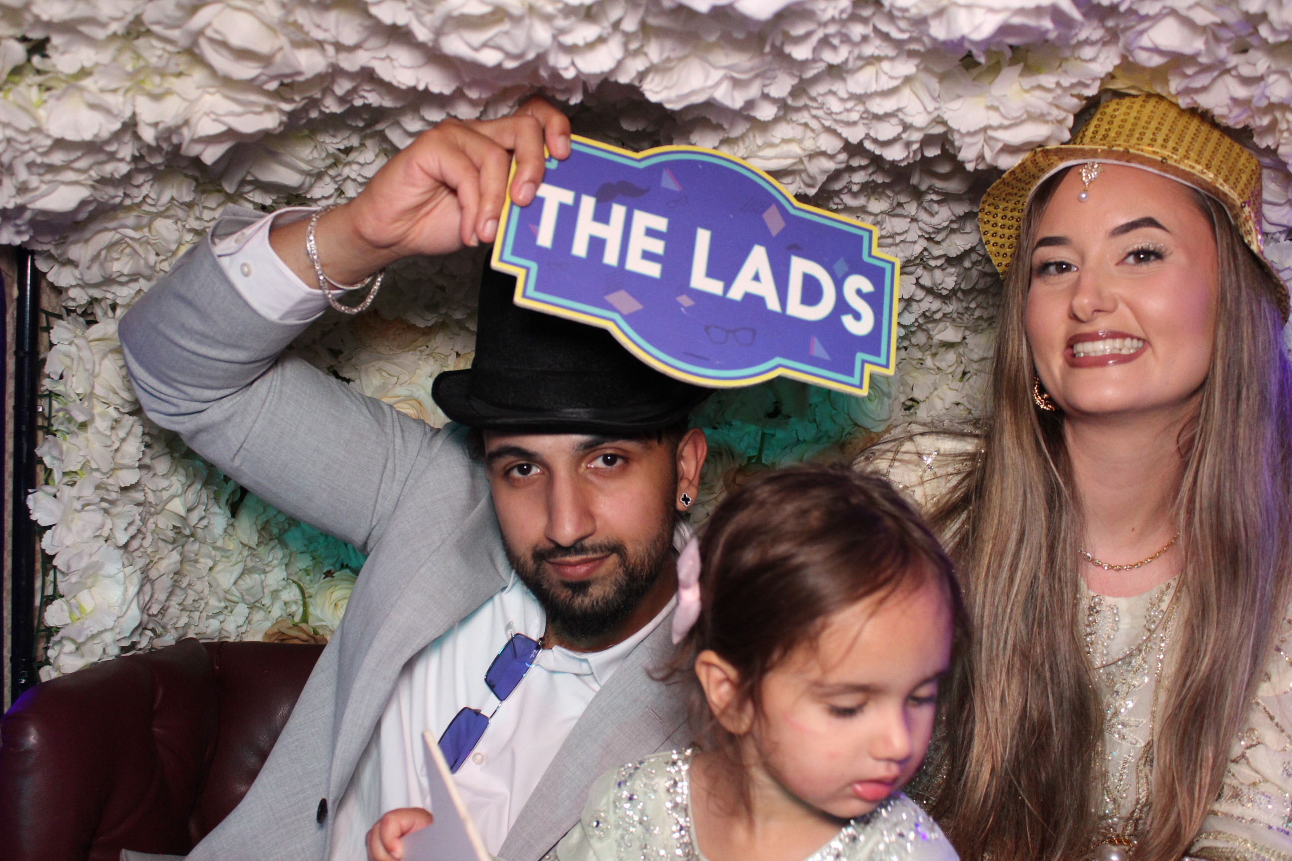 Wedding guests wearing silly hats in a colourful photobooth experience
